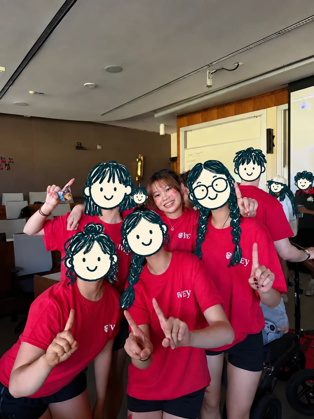 Chloe and friends in red Ivey shirts, with cartoon doodles covering friends’ faces
