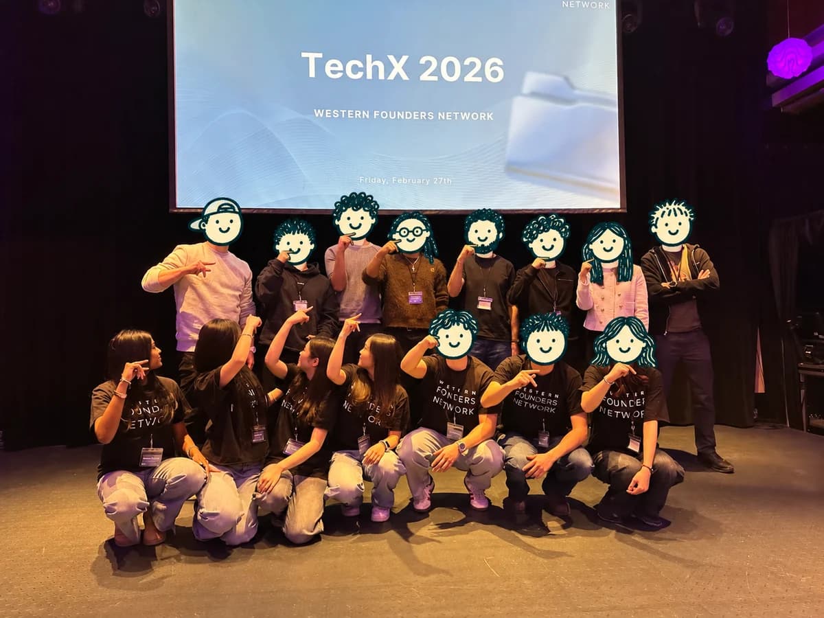 TechX 2026 stage photo with cartoon doodles covering forward-facing faces